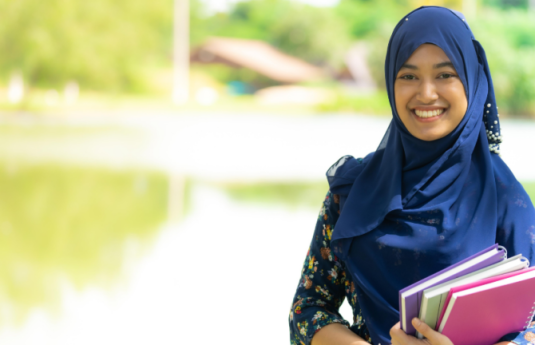 Muslim-woman-holding-books-and-smiling-1536x432